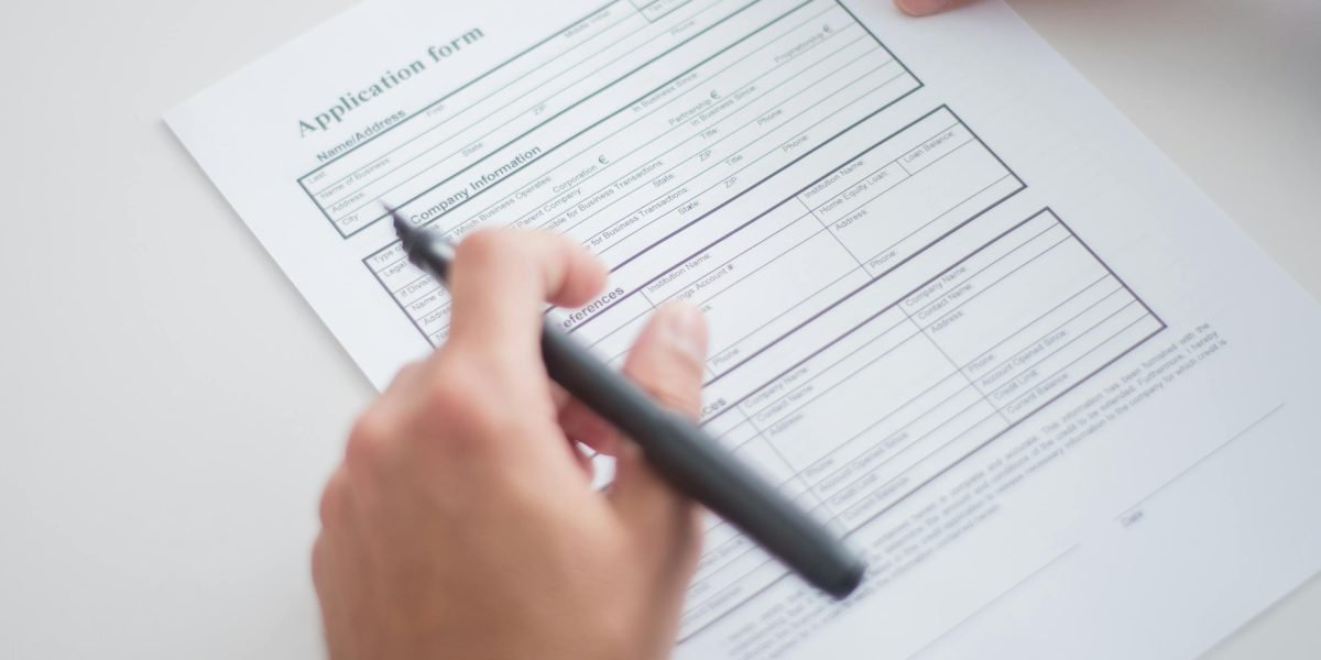A hiring manager carefully reviews a resume, seeking genuine indicators of teamwork.
