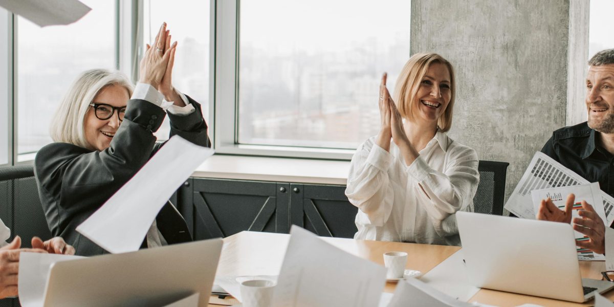 A diverse team works together with enthusiasm, reflecting the positive and engaging spirit of effective team building.
