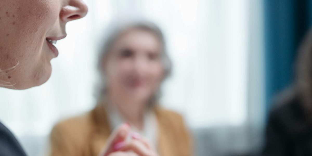 An experienced mentor guiding a team through a debriefing discussion, helping them connect recent experiences to future actions.